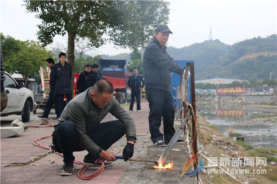 電焊工人在執法人員的指導下，拆除人行道外的鐵柵欄，這些鐵柵欄為非法私建物品。.jpg